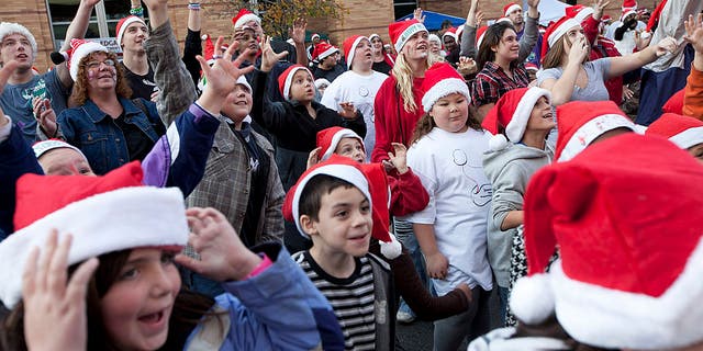 People in the crowd reach out to try to grab the free T-shirts that are thrown during the event. The city of Brockton competes for the largest number of people wearing Santa hats in one place in downtown Brockton, Massachusettes, on Sunday, Nov. 20, 2011.