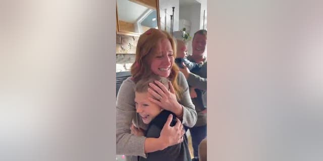 Sarah Molitor hugs one of her sons, who appears excited after learning his newest sibling will be a girl. The family's gender reveal video has gone viral with more than 2.3 million Instagram likes.