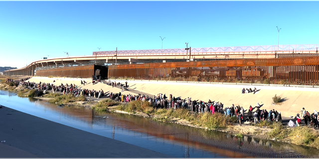 Migrants in line by the Rio Grande