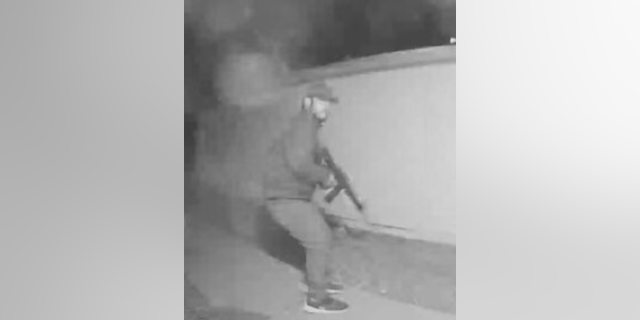 The Phoenix Police Department released surveillance images of one of the suspects holding a rifle outside the home. 