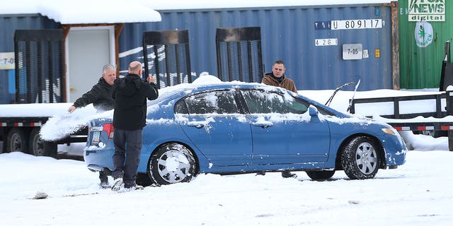 Images captured by Fox News Digital show people removing snow from a blue Honda sedan bearing Arizona plates and then driving it away from the tow lot on Dec.  20, 2022. The vehicle was one of the cars that was towed away from the crime scene and moved to the lot weeks earlier. 