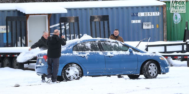 Images captured by Fox News Digital show people removing snow from a blue Honda sedan bearing Arizona plates and then driving it away from the tow lot on Dec. 20, 2022. The vehicle was one of the cars that was towed away from the crime scene and moved to the lot weeks earlier.