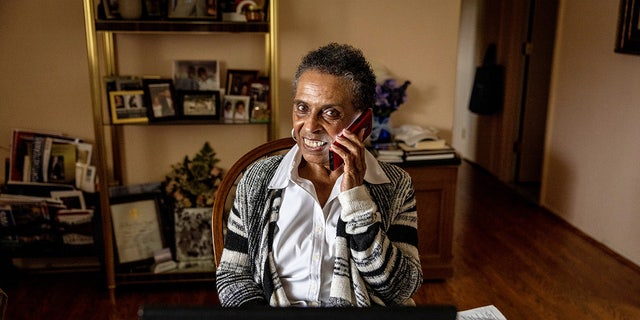 Jacqueline Watkins, 78, on her cell phone, which she favors over her landline because of its portability, is shown on October 27, 2021 at her home in Amityville, New York.