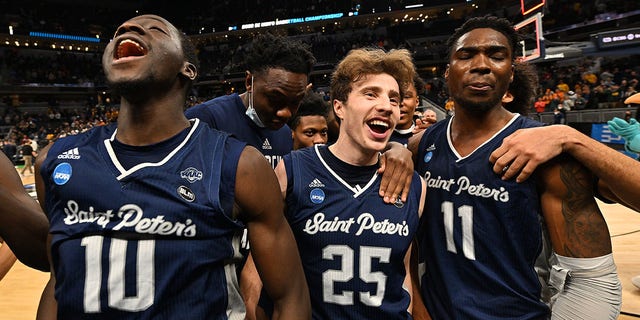 Saint Peter's players, from left, Fousseyni Drame, Doug Edert and KC Ndefo celebrate their victory over the Murray State Racers at Gainbridge Fieldhouse on March 19, 2022 in Indianapolis.