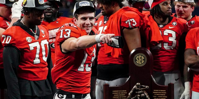 Georgia quarterback Stetson Bennett gestures to the crowd during the trophy presentation the Southeastern Conference Championship game Saturday, Dec. 3, 2022 in Atlanta.