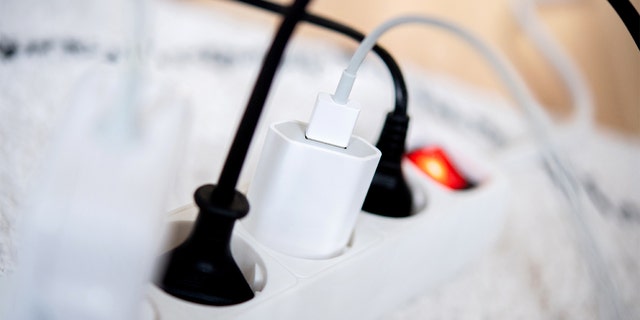 The power plugs of several electrical devices are plugged into a power strip in a living room on November 25, 2022.