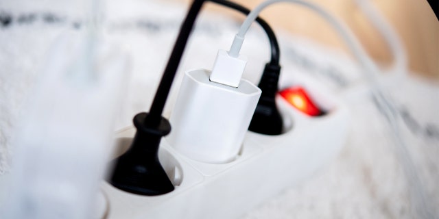 The power plugs of several electrical devices are plugged into a power strip in a living room on November 25, 2022.