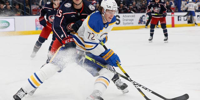Buffalo Sabres' Tage Thompson, right, keeps the puck away from Columbus Blue Jackets' Gavin Bayreuther during the third period of an NHL hockey game Wednesday, Dec. 7, 2022, in Columbus, Ohio.