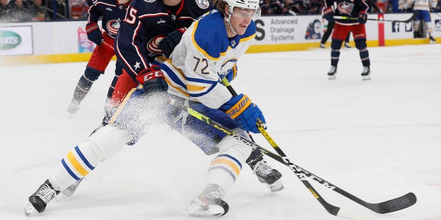 Buffalo Sabres' Tage Thompson, right, keeps the puck away from Columbus Blue Jackets' Gavin Bayreuther during the third period of an NHL hockey game Wednesday, Dec. 7, 2022, in Columbus, Ohio.