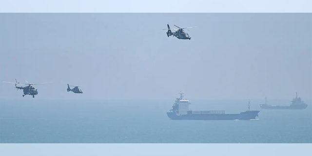 FILE: Chinese military helicopters fly past Pingtan island, one of mainland China's closest point from Taiwan, in Fujian province on August 4, 2022, ahead of massive military drills off Taiwan following US House Speaker Nancy Pelosi's visit to the self-ruled island. 