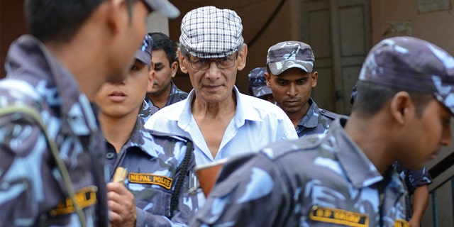 French serial killer Charles Sobraj is escorted by Nepali police in a district court to hear a case related to the June 12, 2014 murder of Canadian backpacker Laurent Ormond Carriere in Bhaktapur. 