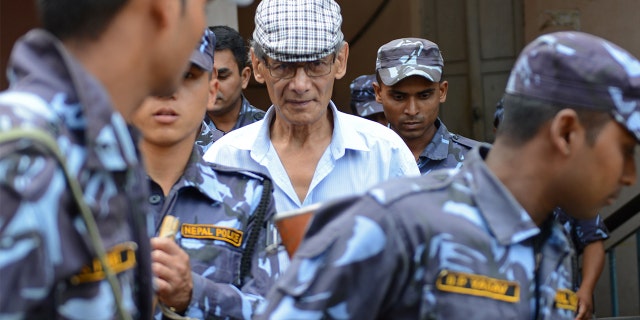 French serial killer Charles Sobhraj is escorted by Nepalese police at a district court for a hearing on a case related to the murder of Canadian backpacker Laurent Ormond Carriere, in Bhaktapur on June 12, 2014. 