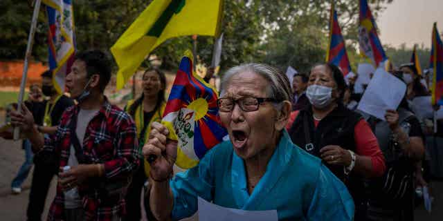 Exile Tibetan activists hold blank white papers symbolizing government censorship in China, while shouting anti-China slogans during a protest in New Delhi, India, Friday, Dec. 2, 2022.