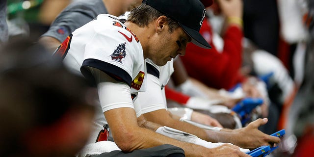Tom Brady #12 of the Tampa Bay Buccaneers looks at a tablet during a game against the New Orleans Saints at Caesars Superdome on September 18, 2022 in New Orleans, Louisiana.