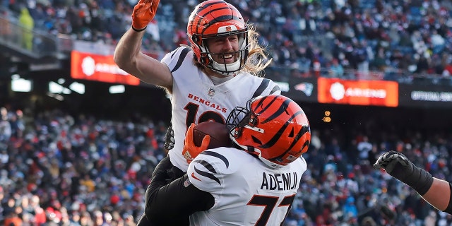 Cincinnati Bengals wide receiver Trenton Irwin, top, celebrates his touchdown with Cincinnati Bengals guard Hakeem Adeniji, #77, during the first half of an NFL football game against the New England Patriots, the Saturday, December 24, 2022, in Foxborough, Massachusetts.