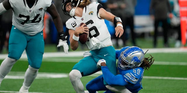 Jacksonville Jaguars quarterback Trevor Lawrence (16) is sacked by Detroit Lions linebacker James Houston IV during the first half, Dec. 4, 2022, in Detroit.