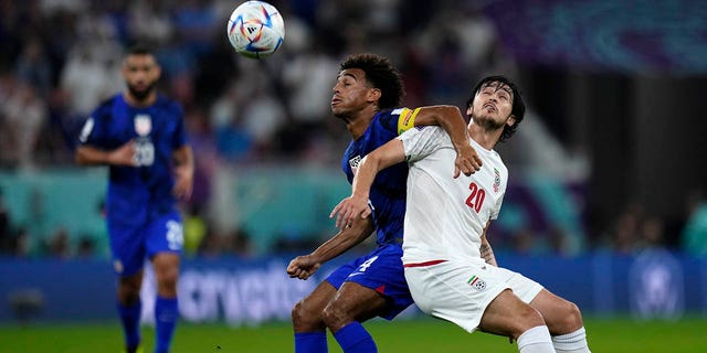 Iran's Sardar Azmoun, right, challenges Tyler Adams of the United States during the World Cup Group B soccer match between Iran and the United States at the Al Thumama Stadium in Doha, Qatar, Tuesday, Nov. 29, 2022. 