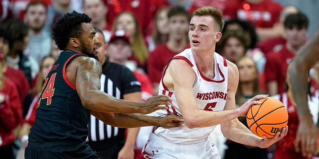 Wisconsin's Tyler Wahl, #5, looks to pass the ball as Maryland's Donta Scott, #24, defends during the first half of an NCAA college basketball game Tuesday, Dec. 6, 2022, in Madison, Wisconsin.