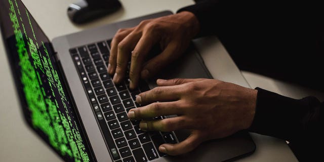 man typing on laptop