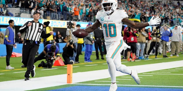 Miami Dolphins wide receiver Tyreek Hill (10) scores a touchdown after recovering a fumble during the first half of an NFL football game against the Los Angeles Chargers Sunday, Dec. 11, 2022, in Inglewood, Calif.