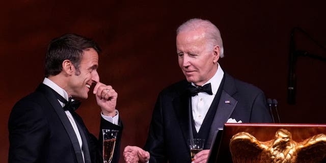 President Joe Biden, right, and French President Emmanuel Macron share a toast after speaking at the state dinner on the South Lawn of the White House on December 1, 2022.
