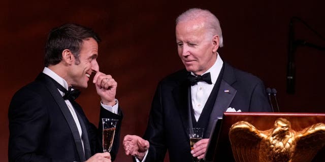 President Joe Biden, right, and French President Emmanuel Macron share a toast after speaking at the state dinner on the South Lawn of the White House on December 1, 2022.