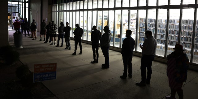 Residents wait in line to vote early outside a polling station on Nov. 29, 2022, in Atlanta.