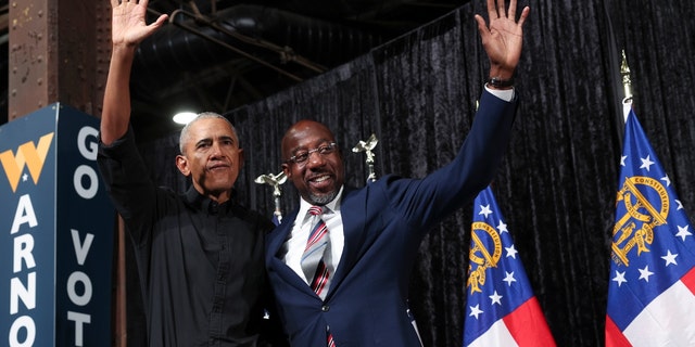 Former President Barack Obama, left, campaigns with Sen. Raphael Warnock, D-Ga., at a rally Thursday.