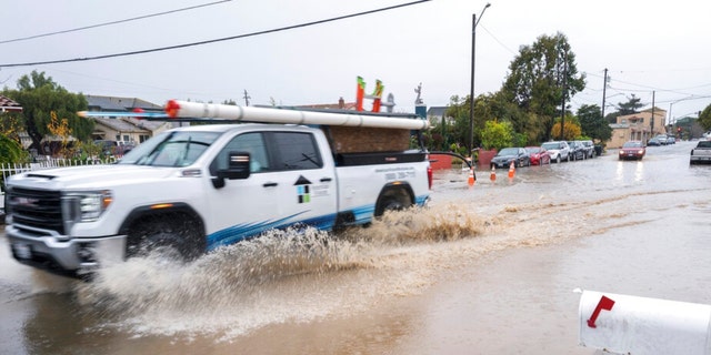 A truck drives through a flooded intersection of E Bolivar Street in Salinas, California, Tuesday, Dec. 27, 2022.