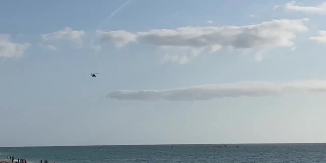 A helicopter scans the waters. 
