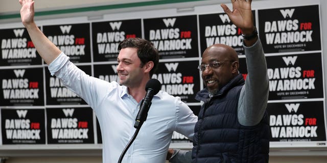 Georgia Democratic Senate candidate U.S. Sen. Raphael Warnock (D-GA), right, and Sen. Jon Ossoff (D-GA) wave to students before speaking at a Dawgs for Warnock rally at the University of Georgia Dec. 4, 2022 in Athens, Georgia.