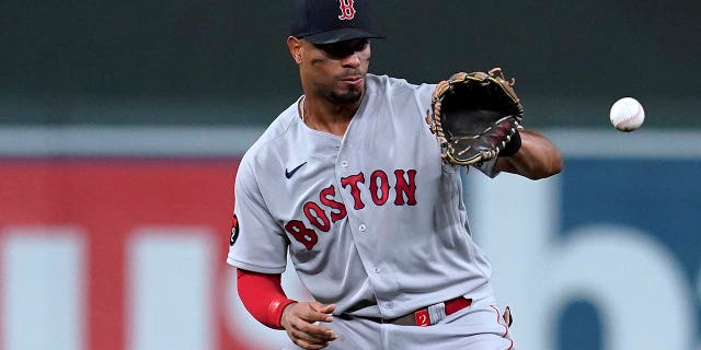 Boston Red Sox's Xander Bogaerts fields the ball hit by Minnesota Twins' Luis Arraez during the fifth inning of a baseball game Aug. 31, 2022, in Minneapolis.