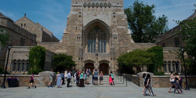 A tour group makes a stop at the Sterling Memorial Library on the Yale University campus in New Haven, Connecticut, June 12, 2015.