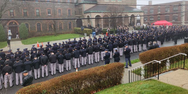 Police stand in a guard of honor for fallen Yonkers Police Sgt. Frank Gualdino, whose funeral Mass was celebrated at Sacred Heart Church in Yonkers, N.Y., on Dec. 7, 2022. The 53-year-old sergeant was killed in the line of duty last week in a head-on crash.