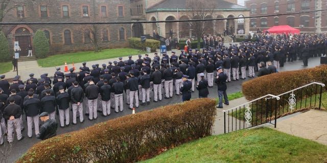 Police stand in a guard of honor for fallen Yonkers Police Sgt. Frank Gualdino, whose funeral Mass was celebrated at Sacred Heart Church in Yonkers, N.Y., on Dec. 7, 2022. The 53-year-old sergeant was killed in the line of duty last week in a head-on crash.