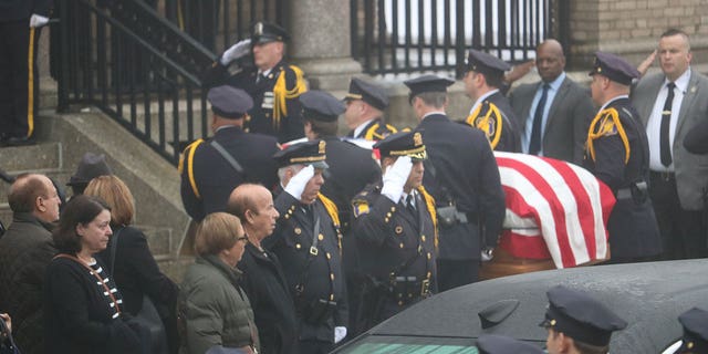 Police salute the coffin of Yonkers Police Sgt. Frank Gualdino, whose funeral Mass was celebrated at Sacred Heart Church in Yonkers, N.Y., on Dec. 7, 2022.