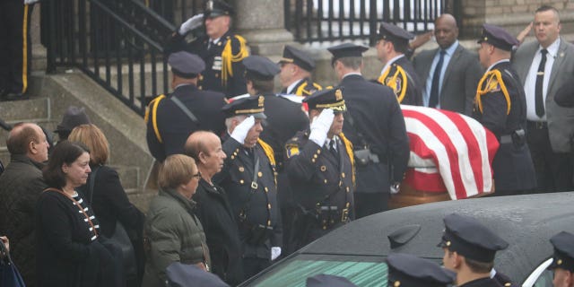 Police salute the coffin of Yonkers Police Sgt. Frank Gualdino, whose funeral Mass was celebrated at Sacred Heart Church in Yonkers, N.Y., on Dec. 7, 2022.