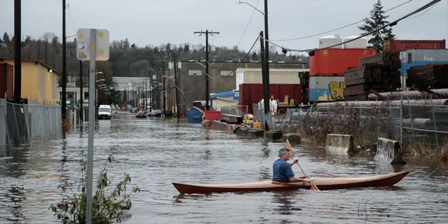 A person kayaks on South Portland Street in Seattle's South Park neighborhood Tuesday morning, Dec. 27, 2022.