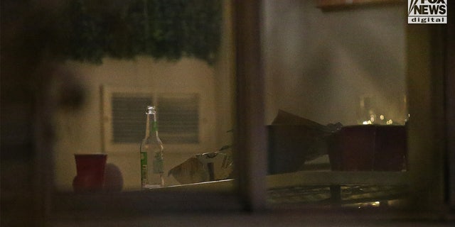 A beer bottle can be seen inside the house.