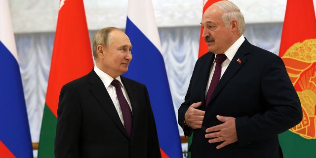 Russian President Vladimir Putin, left, and Belarussian President Alexander Lukashenko, right, are seen during the welcoming ceremony on Dec. 19, 2022, in Minsk, Belarus.