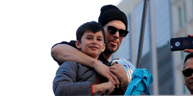 Tom Brady poses with son Benjamin during the New England Patriots' Super Bowl Victory Parade through the streets of Boston on Feb. 5. 2019.