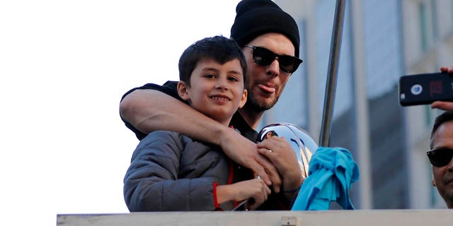 Tom Brady poses with son Benjamin during the New England Patriots' Super Bowl Victory Parade through the streets of Boston on Feb. 5. 2019.