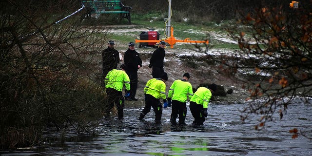 Police search teams at the scene after children fell through ice in Babbs Mill Park in Kingshurst, Solihull, England, Monday, Dec. 12, 2022. Three of the boys died after being pulled from the water.