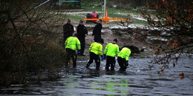 Police search teams at the scene after children fell through ice in Babbs Mill Park in Kingshurst, Solihull, England, Monday, Dec. 12, 2022. Three of the boys died after being pulled from the water.