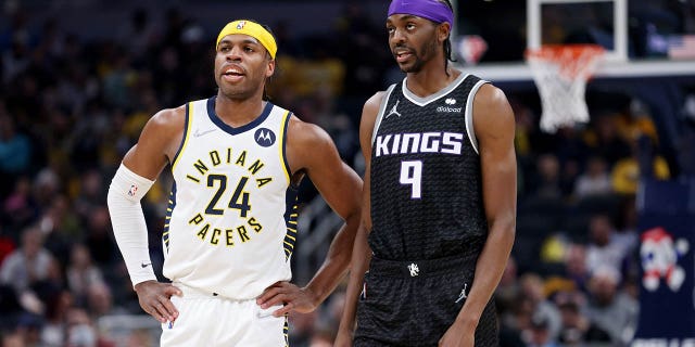 Buddy Hield (24) de los Indiana Pacers y Justin Holiday (9) de los Sacramento Kings se enfrentan en el primer cuarto en Gainbridge Fieldhouse el 23 de marzo de 2022 en Indianápolis.