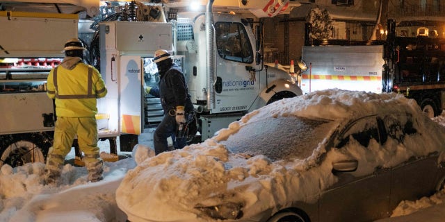 National Grid technicians work in Buffalo, New York, on December 26, 2022. - Emergency crews in New York were scrambling on December 26, 2022, to rescue marooned residents from what authorities called the "blizzard of the century," a relentless storm that has left at least 25 dead in the state and is causing US Christmas travel chaos. (Photo by Joed Viera / AFP) (Photo by JOED VIERA/AFP via Getty Images)