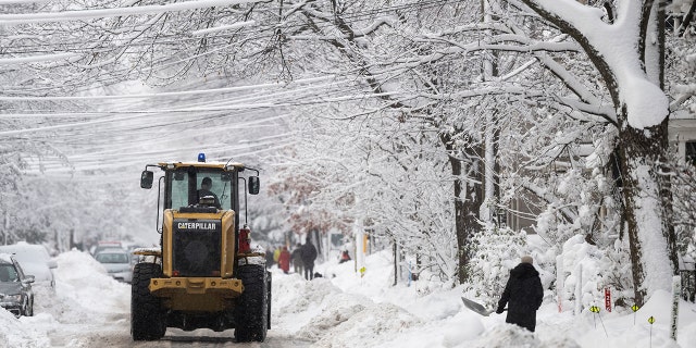 A snowplow makes its way along a street in Ottawa after a snowstorm, on Saturday, Dec. 17, 2022.