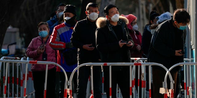 Des résidents font la queue pour leur test de routine COVID-19 sur un site de test de coronavirus à Pékin, le 7 décembre 2022.