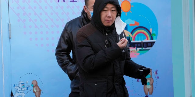 A resident takes off a mask during the COVID test in Beijing on Wednesday, December 7, 2022. In a sharp reversal, China has announced a series of measures that roll back some of the most draconian anti-COVID-19 restrictions.