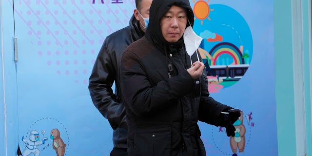 A resident pulls away a mask during COVID test in Beijing, Wednesday, Dec. 7, 2022. In a sharp reversal, China has announced a series of measures rolling back some of the most draconian anti-COVID-19 restrictions.